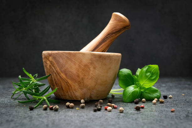 Mortar and pastle with fresh herbs on Dark background