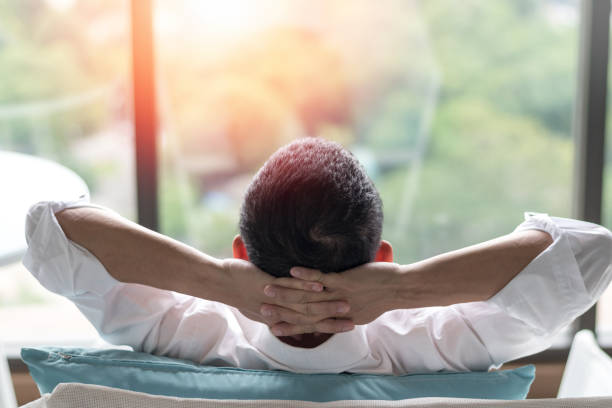 buena vida y fácil relajar el estilo de vida hombre de negocios después del trabajo desde casa sentado detrás de la cabeza para personas de negocios felices. concepto de equilibrio de la vida laboral. - evasión fotografías e imágenes de stock