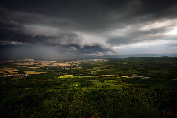 A severe thunderstorm shelf cloud races across the country side on a summer afternoon