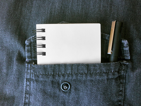 Empty notebook and pencil in shirt pocket. To do list concept.