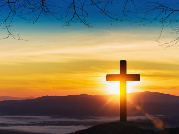 istock Silhouette of cross on mountain sunset background. 1220029567