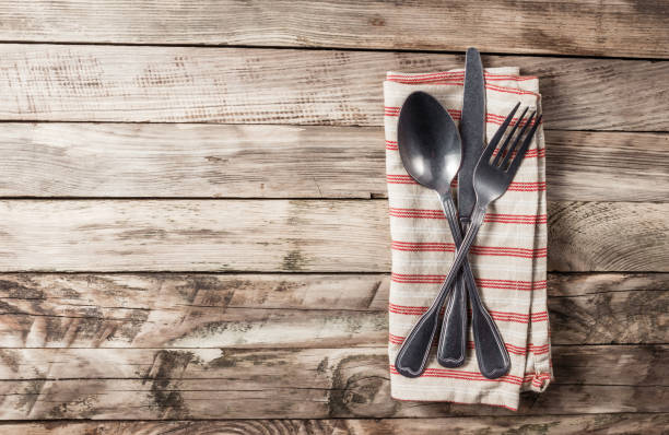 istock Vintage Table setting with napkin and cutlery on old rustic wooden table. 1220030314