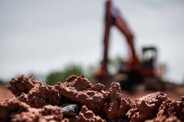 оранжевый экскаватор на стройплощадке - earth mover digging land bulldozer стоковые фото и изображения
