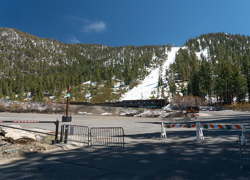Empty parking lot at Heavenly Mountain Resort in Lake Tahoe, California/Nevada with a view of the lower section of the mountain .  The resort closed for the season in March 2020 due to COVID-19.