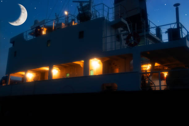 Crescent moon rising over the anchored industrial ship with copy space.