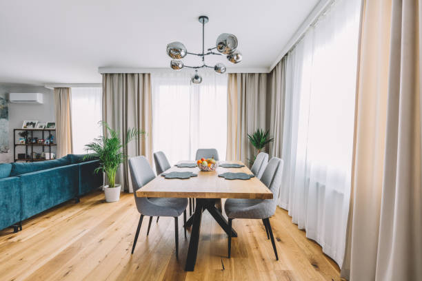 Dining room with wooden table and floor in modern apartment. Interior design