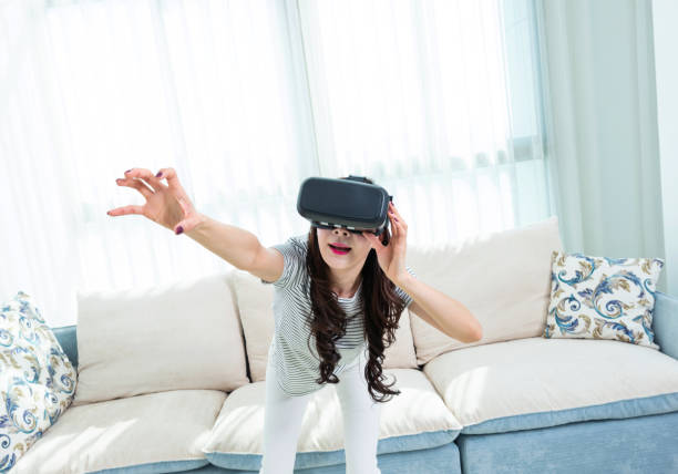 istock Woman wearing virtual reality simulator at home 1220037699