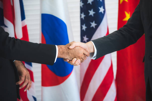 istock Business people shake hands, international flag background 1220039064