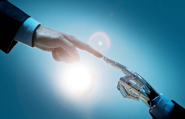 istock Businessman finger touching robot finger 1220044745