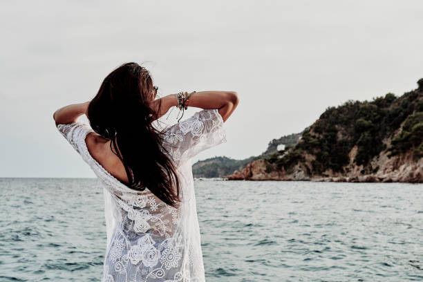 istock a young woman at sunset in a boat - summer concept 1220045363