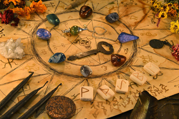 istock Ouija spiritual board with runes and magic objects on witch table. 1220045806