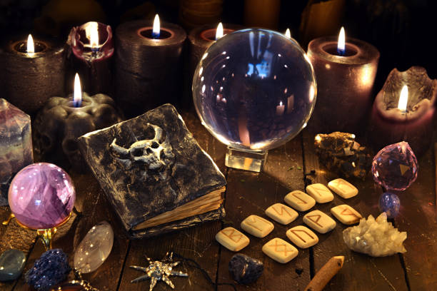 istock Crystal ball, diabolic book and runes on witch table. 1220046466