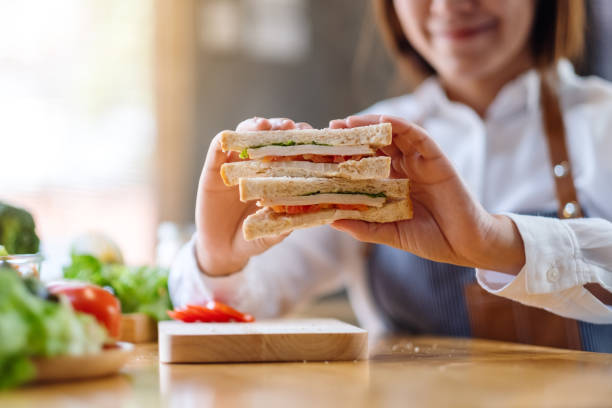 istock a female chef cooking and showing a whole wheat sandwich in kitchen 1220046599
