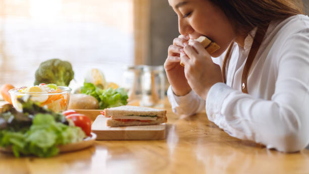 istock a female chef cooking and eating a whole wheat sandwich in kitchen 1220046613