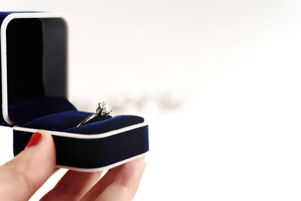 istock stylish luxury ring with diamond in blue box in hand on white background, present and love concept, valentine's day proposal 1220055639