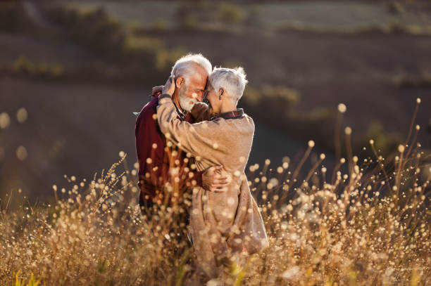 istock Affectionate senior couple embracing during autumn day in tall grass. 1220055756