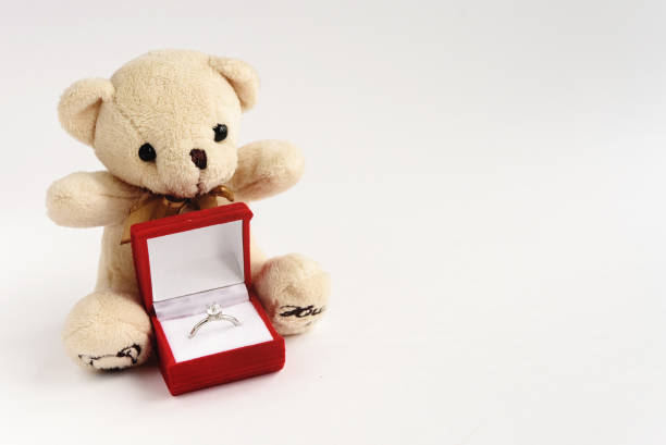 istock stylish luxury ring with diamond in red box and teddy bear on white background, valentine's day concept 1220055773