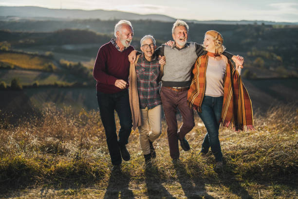 istock Happy senior couples walking embraced in autumn day. 1220055782