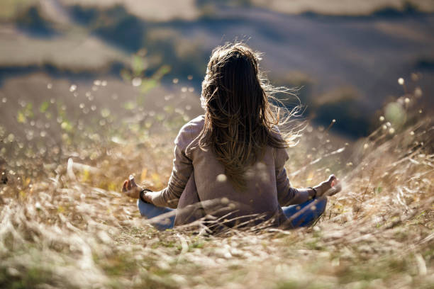 istock Back view of relaxed woman meditating on a hill. 1220056581