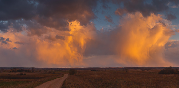 Cumulonimbus storm clouds at red sunset light, Lithuania