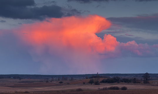 Cumulonimbus storm clouds at red sunset light, Lithuania