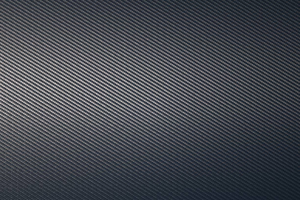 istock Close up of grey diagonal oriented woven carbon fibre sheet surface. 1220059444