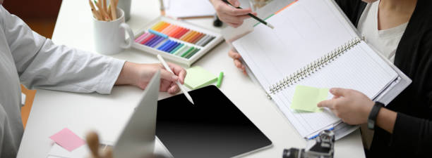 istock Cropped shot of designer team brainstorming on their project with digital tablet, paper work and designer supplies 1220062050