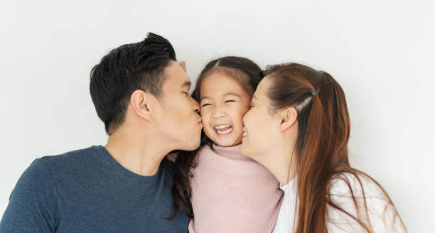Happy Asian family. Young Father and Mother kiss in their daughter cheek together. Happy Asian family. Young Father and Mother kiss in their daughter cheek together. Love emotion, Smiling face, Enjoying, Joyful. cheek photos stock pictures, royalty-free photos & images