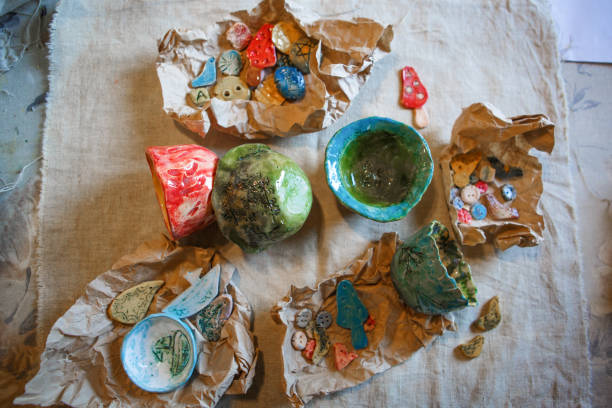 istock Clay blanks for children's creativity at the master class in eco-Park. Layout on the table of clay vessels, plates, buttons 1220063193