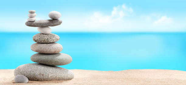 istock Pyramid of sea pebbles on a sunny sand beach 1220064404