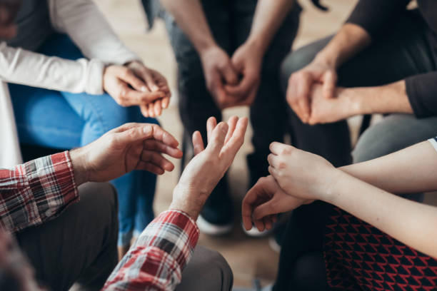 Close-up of hands of people sitting in a circle during a therapy group meeting Close-up of hands of people sitting in a circle during a therapy group meeting mental illness photos stock pictures, royalty-free photos & images