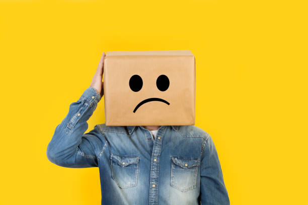 istock Man with his head in a box and sadness gesture drawn on it 1220067008