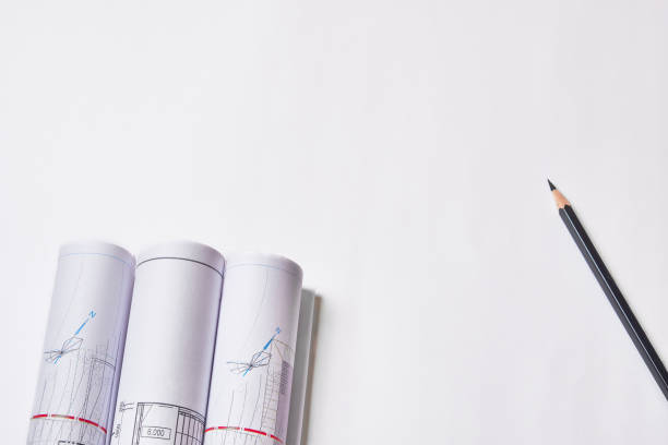 istock Rolled engineering drawings and pencil at blank white background with copy space 1220067158