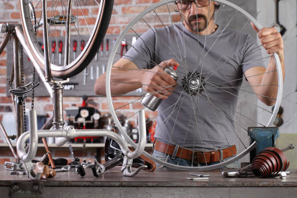 istock man repair the vintage bicycle in garage workshop on the workbench with tools, diy concept 1220067270