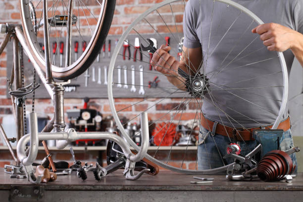 istock man repair the vintage bicycle in garage workshop on the workbench with tools, diy concept 1220067272