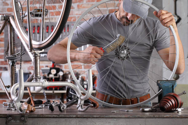 istock man repair the vintage bicycle in garage workshop on the workbench with tools, diy concept 1220067276