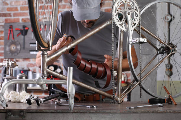 istock man repair the vintage bicycle in garage workshop on the workbench with tools, diy concept 1220067291