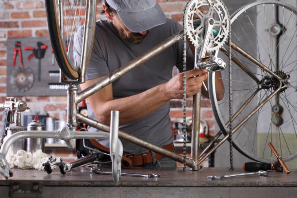 istock man repair the vintage bicycle in garage workshop on the workbench with tools, diy concept 1220067298