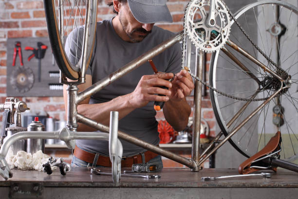 man repair the vintage bicycle in garage workshop on the workbench with tools, diy concept