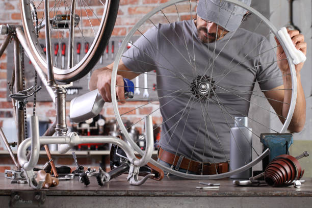 istock man repair the vintage bicycle in garage workshop on the workbench with tools, diy concept 1220067301
