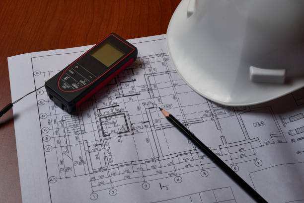 istock Laser meter, white hardhat and drawings at engineer workplace 1220067333