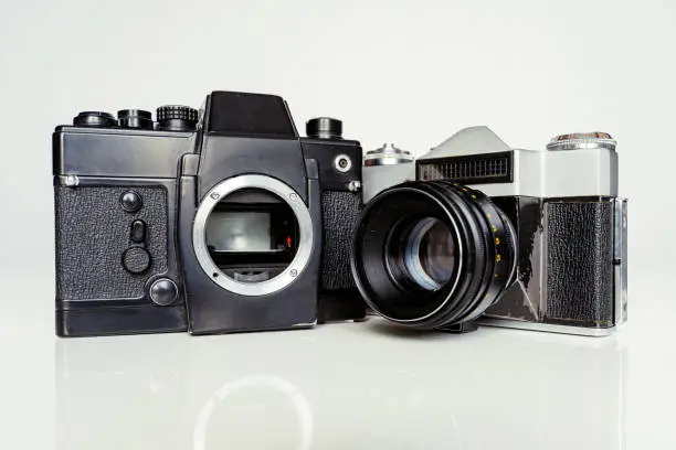 Photo of A couple of soviet union cameras Zenit E produced in 60s and 80s as an analogue to the German Leica. Very old film cameras in shabby shape.