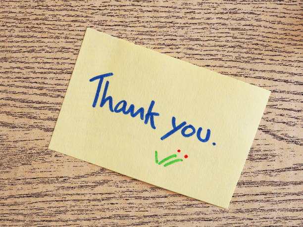 istock Thank you handwriting on post-it notes on a wooden board. 1220068442