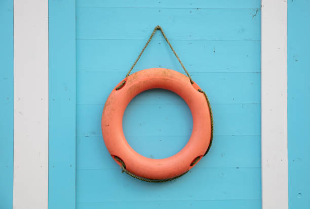 Orange lifebuoy hanging on a blue wall