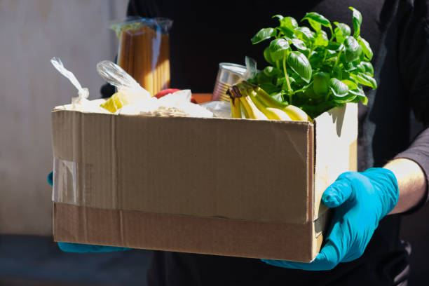 Home delivery during an epidemic. contactless delivery. Food donation. Men's hands hold a box with products. Home delivery during an epidemic. contactless delivery. Food donation. Men's hands hold a box with products fruit carving stock pictures, royalty-free photos & images
