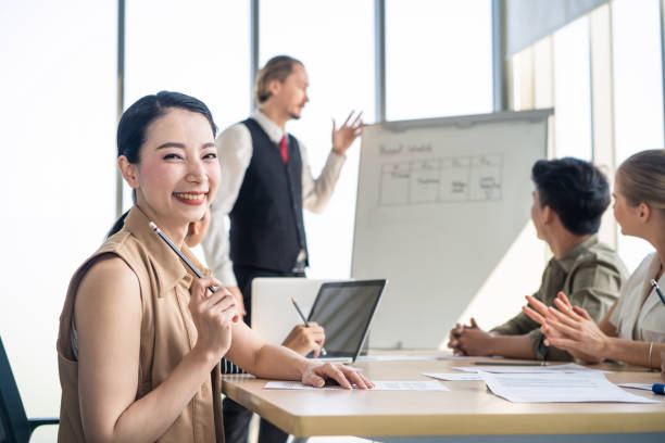istock Asian woman and team work brainstorm to solve problem and presentation new idea. People discuss and smile on new challenge topic in meeting room. Business finance and communication planning concept. 1220073622