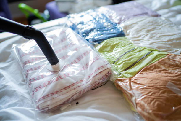Space saving Packing clothes, towels and bed sheets  in a vacuum bags vacuum packed stock pictures, royalty-free photos & images