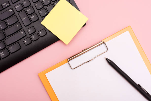 istock Yellow empty sticker on a black keyboard on a pink desktop. 1220076853