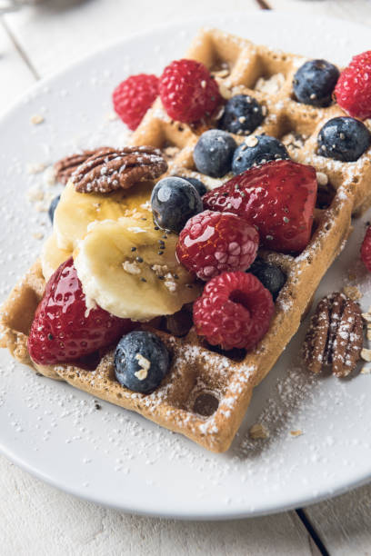 istock Waffle topped with banana slices, oat, pecans and berries. 1220077928