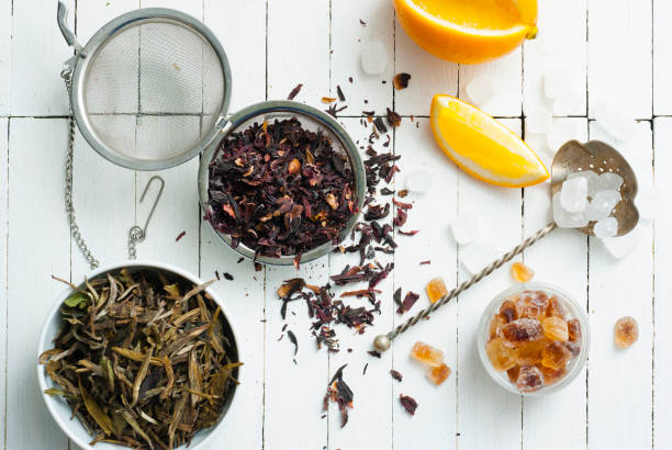 Tea variations green and black herbal tea crop variation with lemon, rock sugar and infuser, on white wooden table background nub stock pictures, royalty-free photos & images